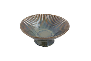 Ceramic bowl with ribbed design on a white background
