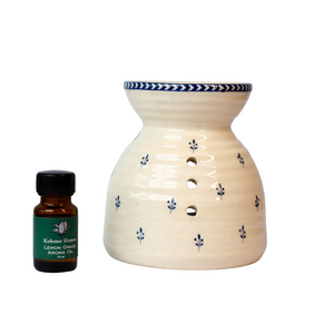 Ceramic oil diffuser with chintz print and a bottle of aroma oil on a white background