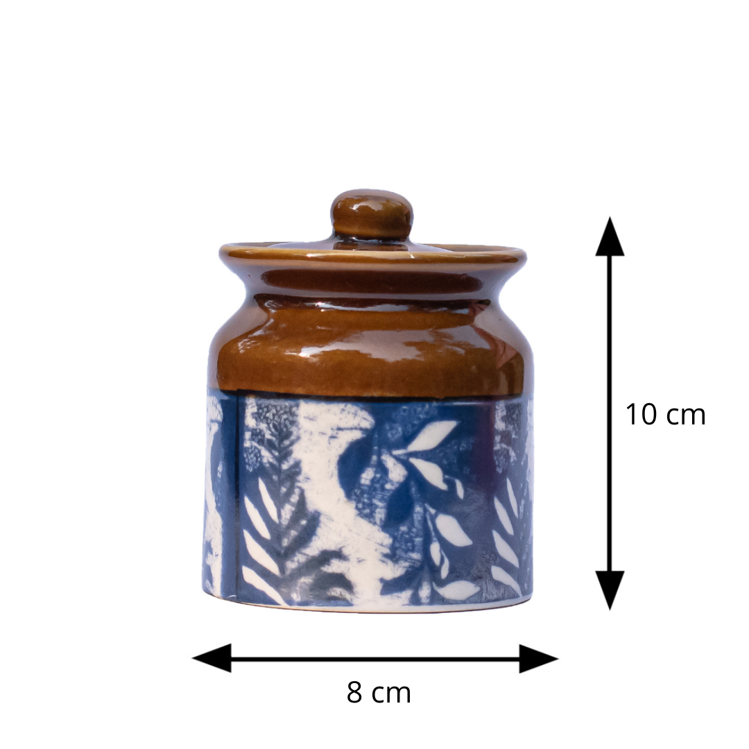 Ceramic jar with blue pattern and brown lid, shown with measurements on a white background