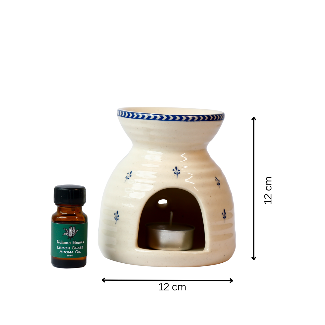 Ceramic oil burner with a small bottle of essential oil on a white background