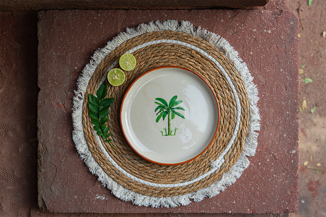 Ceramic plate with palm tree design on a woven placemat