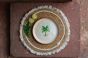 Ceramic plate with palm tree design on a woven placemat