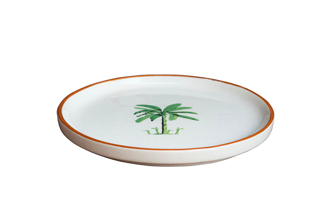 Round ceramic plate with a palm tree design on a white background